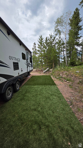 38 Spruce, Unit 38A Evanston, UT 82930 - Photo 13 of 15 Artificial turf pad beside a parked trailer, with a natural treeline in the background