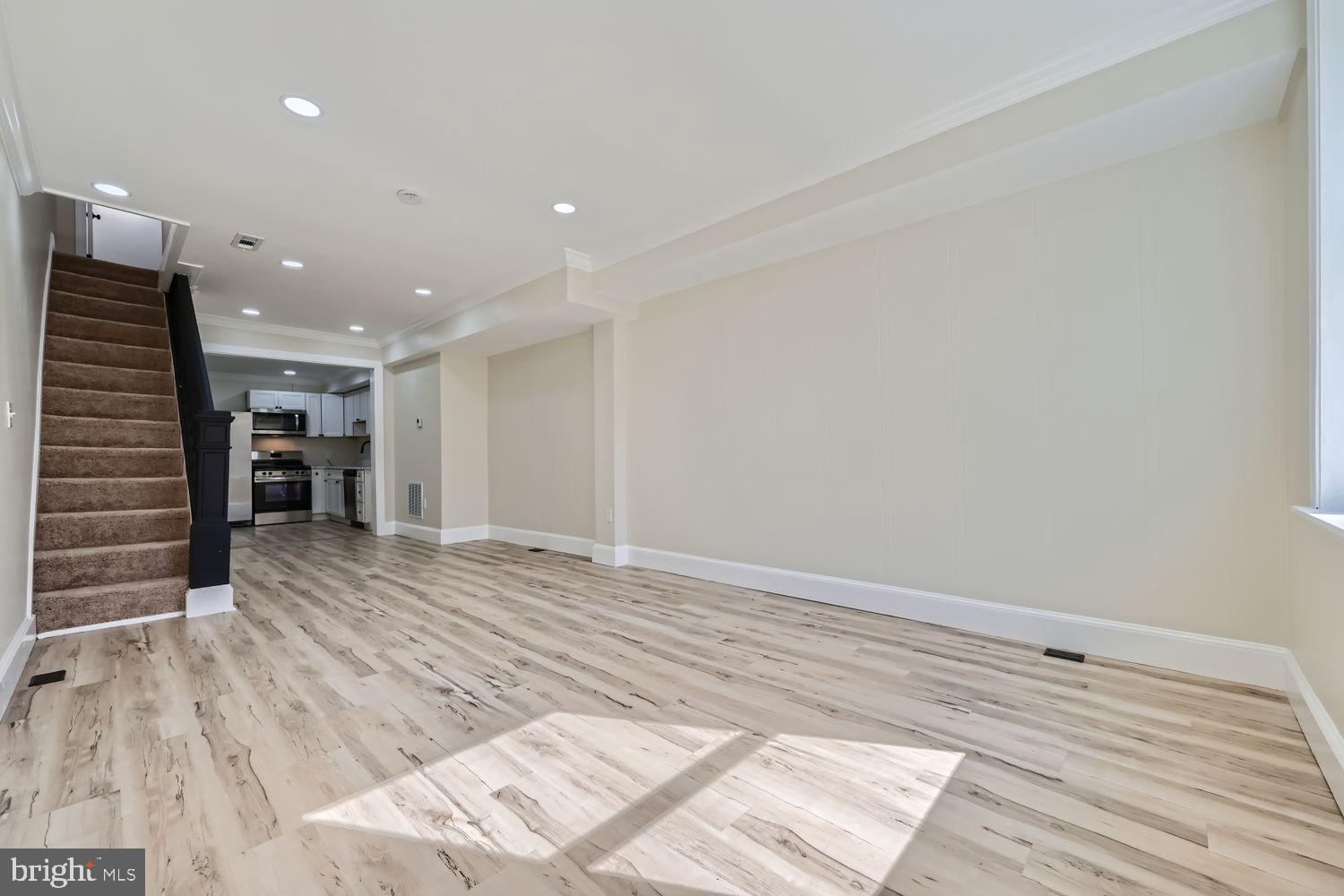 1147 Scott Street Baltimore, MD 21230 - Photo 3 of 28 a view of an empty room with wooden floor and a kitchen
