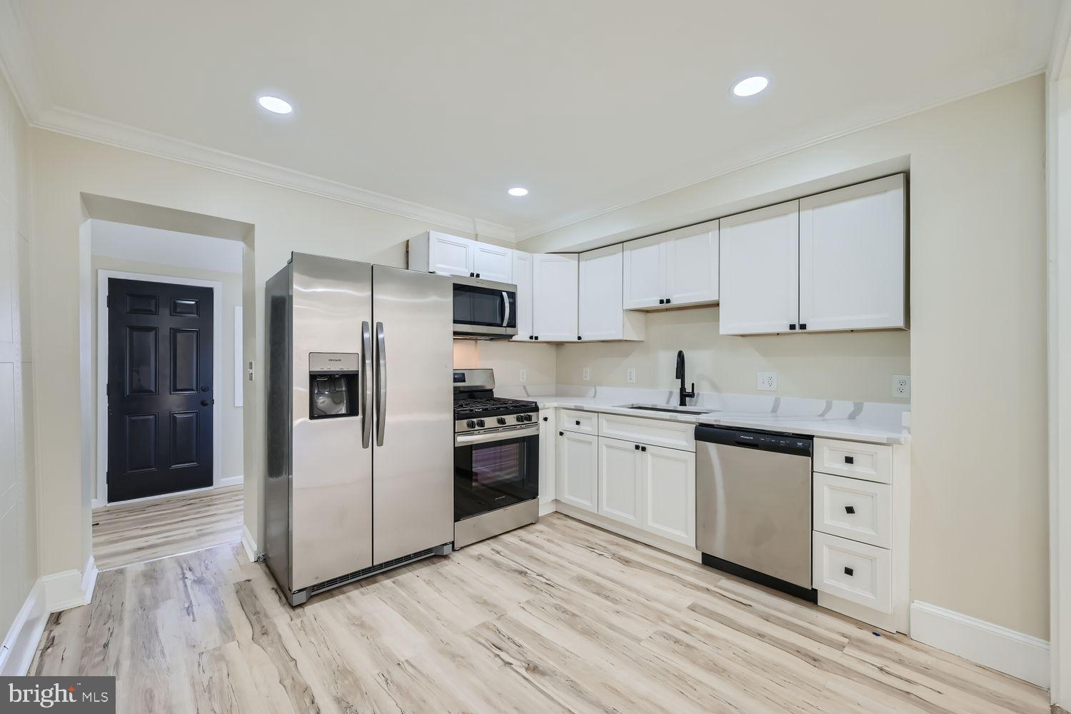 1147 Scott Street Baltimore, MD 21230 - Photo 9 of 28 a kitchen with granite countertop a refrigerator and a stove top oven