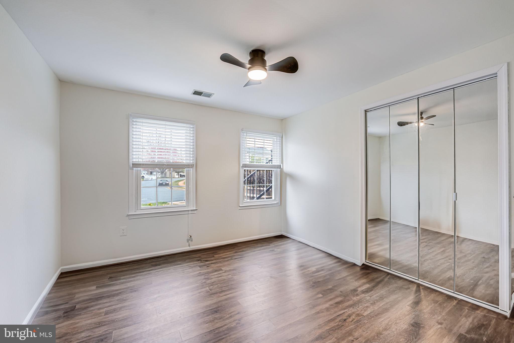 107 Country Road Sterling, VA 20165 - Photo 38 of 58 a view of an empty room with wooden floor and a window
