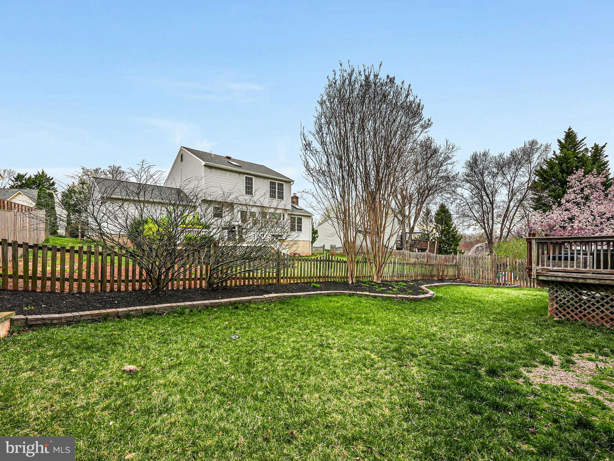 107 Country Road Sterling, VA 20165 - Photo 52 of 58 a view of a yard with large trees and a wooden fence