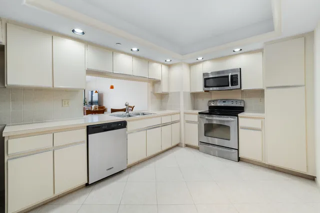 a kitchen with white cabinets and stainless steel appliances