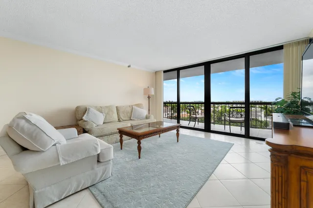 a living room with furniture and a large window with outer view
