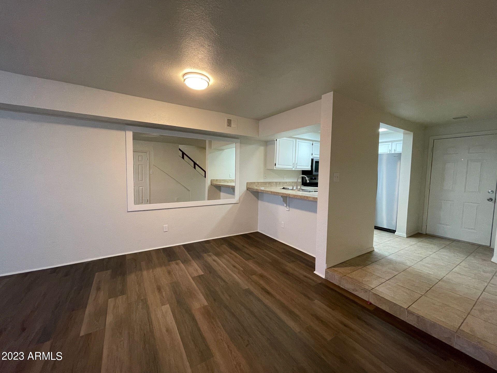 a view of a kitchen with wooden floor and electronic appliances