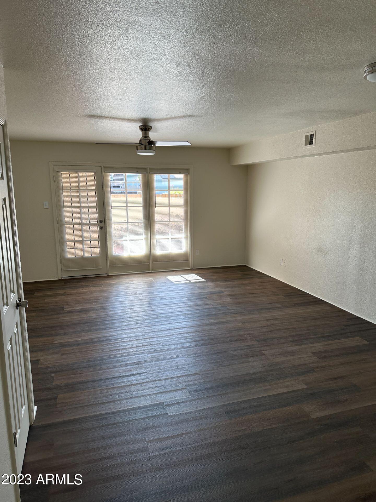 2121 West Union Hills Drive, Unit 108 Phoenix, AZ 85027 - Photo 11 of 35 an empty room with wooden floor and windows
