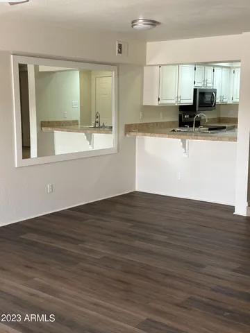 a view of a kitchen with kitchen island a sink wooden floor and counter top space