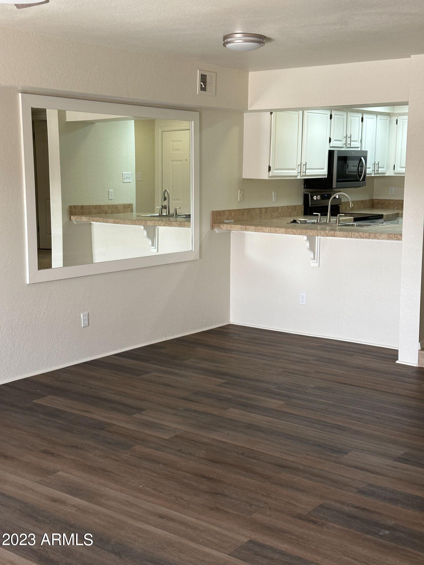 2121 West Union Hills Drive, Unit 108 Phoenix, AZ 85027 - Photo 12 of 35 a view of a kitchen with kitchen island a sink wooden floor and counter top space