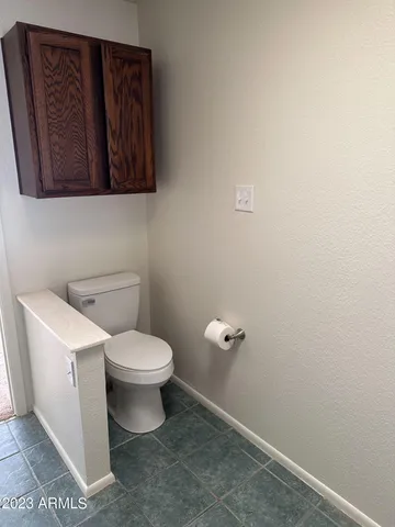 a white toilet sitting next to a white wall