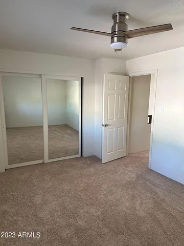 an empty room with fan and entrance