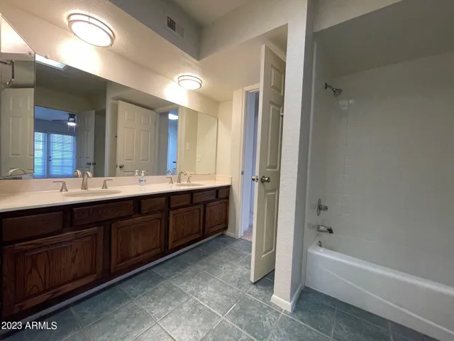 a spacious bathroom with a tub sink shower and mirror
