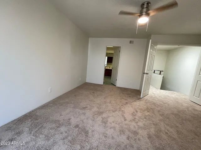 en empty room with windows and ceiling fan