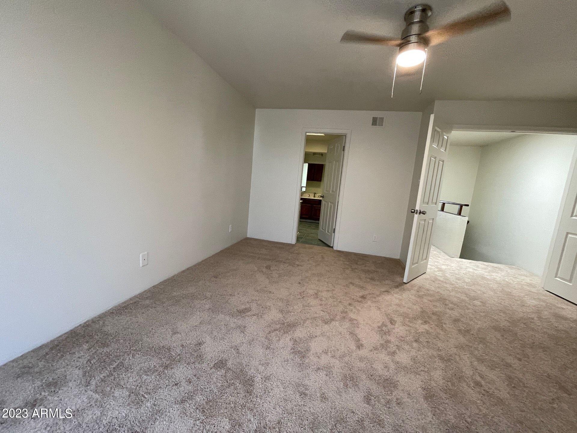 2121 West Union Hills Drive, Unit 108 Phoenix, AZ 85027 - Photo 29 of 35 en empty room with windows and ceiling fan