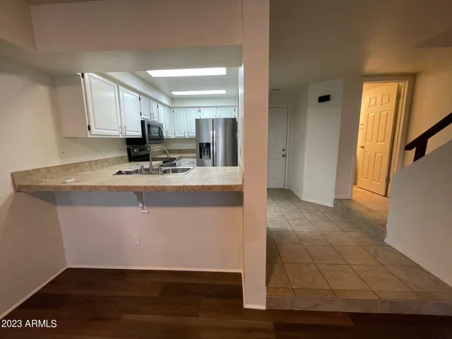 a kitchen with kitchen island granite countertop a sink cabinets and stainless steel appliances