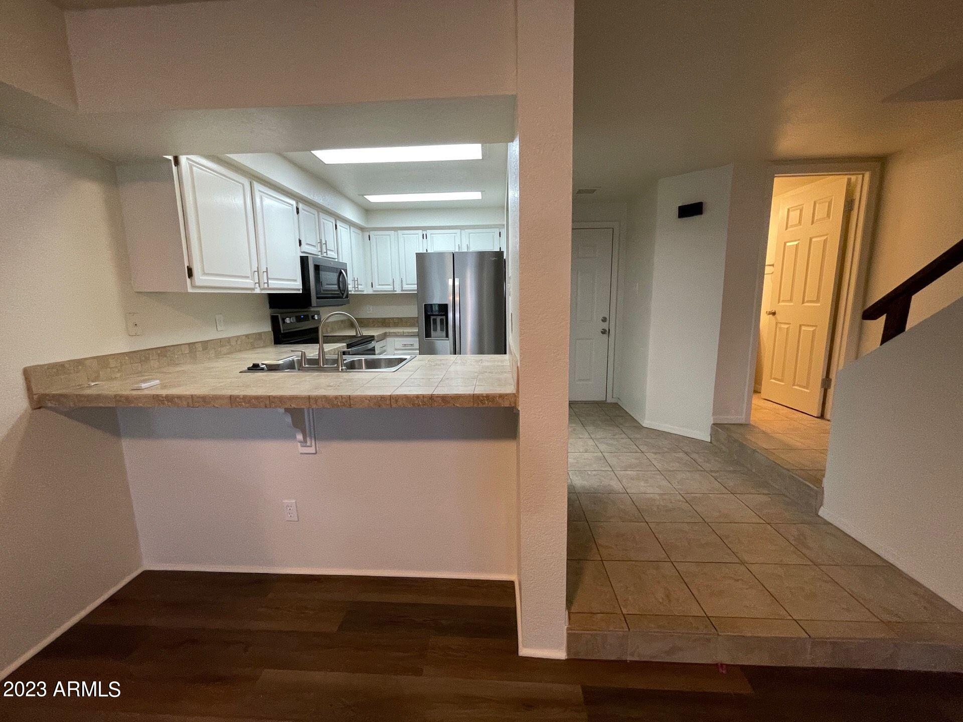 2121 West Union Hills Drive, Unit 108 Phoenix, AZ 85027 - Photo 3 of 35 a kitchen with kitchen island granite countertop a sink cabinets and stainless steel appliances