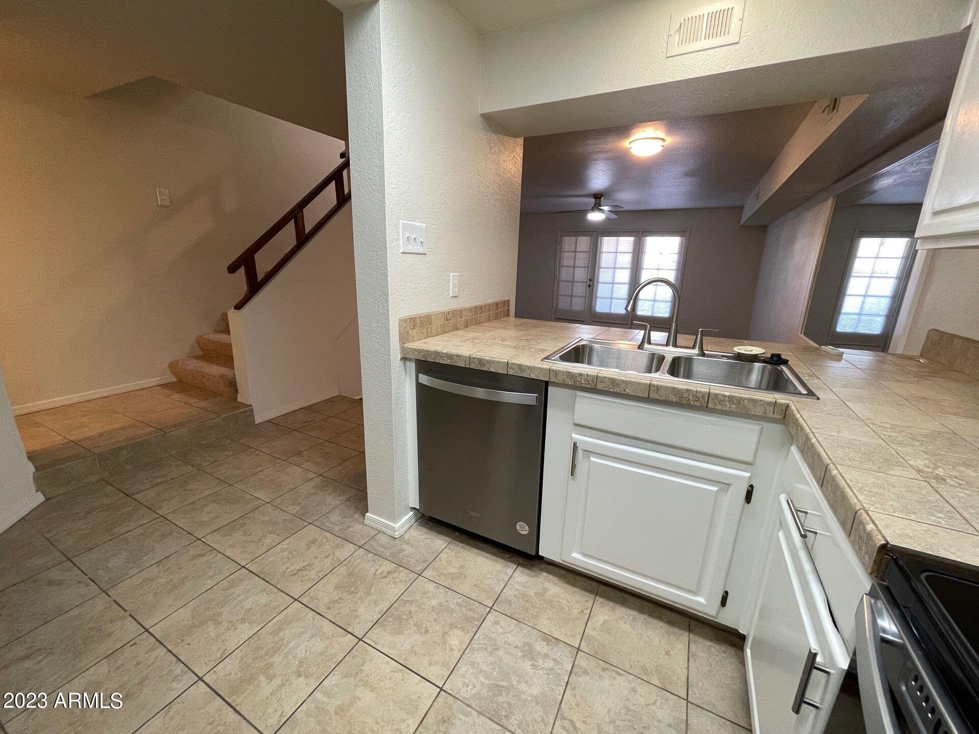 2121 West Union Hills Drive, Unit 108 Phoenix, AZ 85027 - Photo 4 of 35 a kitchen with a sink a stove cabinets and a counter top space