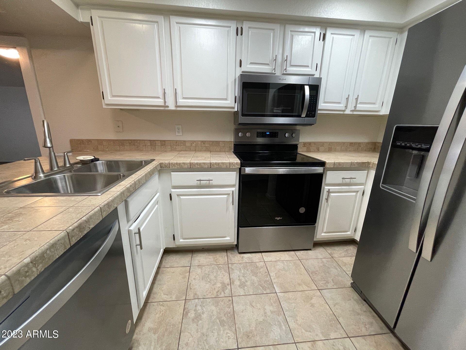2121 West Union Hills Drive, Unit 108 Phoenix, AZ 85027 - Photo 5 of 35 a kitchen with a sink stove and microwave