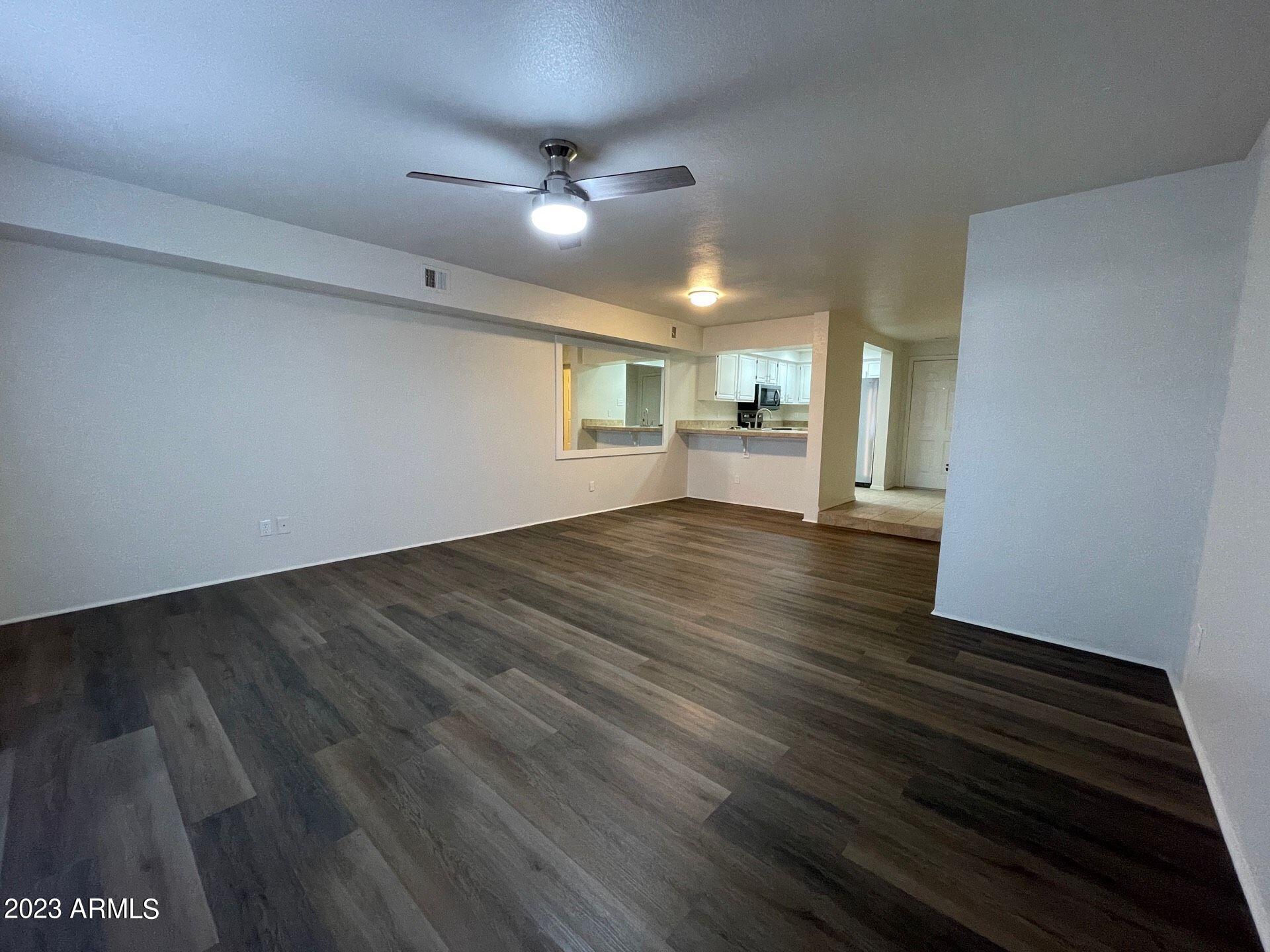2121 West Union Hills Drive, Unit 108 Phoenix, AZ 85027 - Photo 9 of 35 a view of an empty room with wooden floor and a window