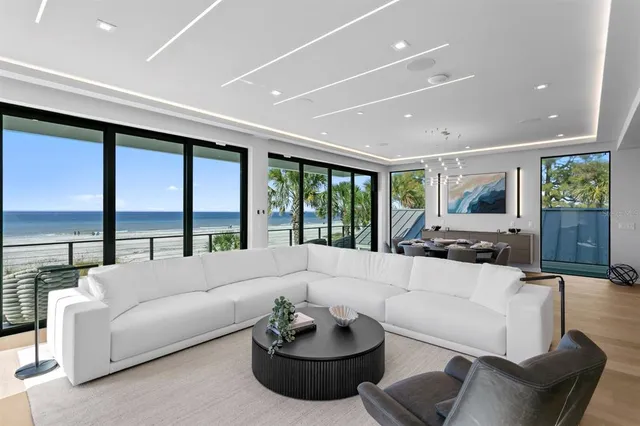 a large dining hall with stainless steel appliances kitchen island granite countertop a large kitchen counter top a stove and a sink with couches