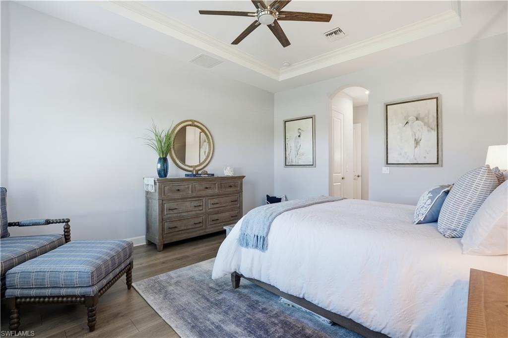 8665 Dilillo Court Naples, FL 34119 - Photo 12 of 42 a bedroom with a bed a couch and dresser