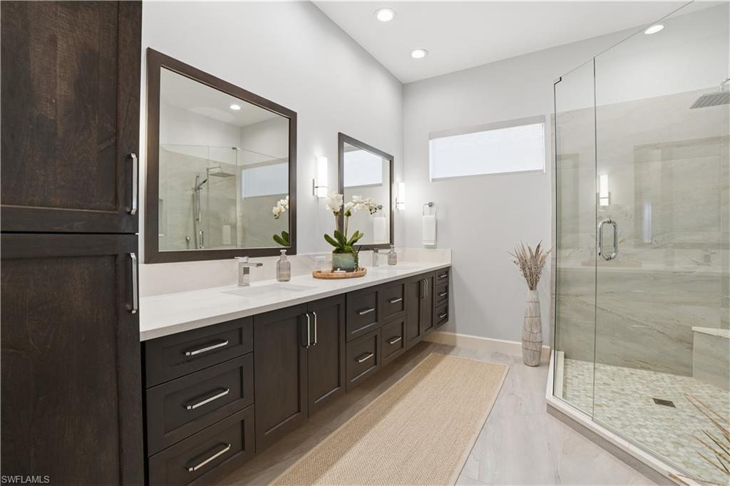 8665 Dilillo Court Naples, FL 34119 - Photo 13 of 42 a bathroom with a double vanity sink mirror and shower