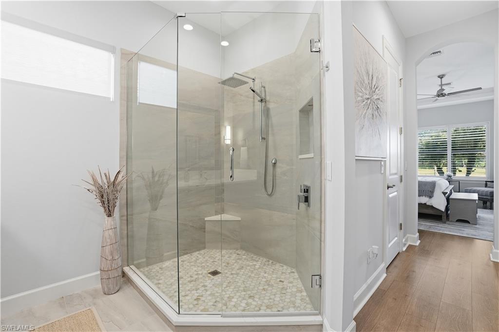 8665 Dilillo Court Naples, FL 34119 - Photo 15 of 42 a bathroom with a glass shower door and a glass door