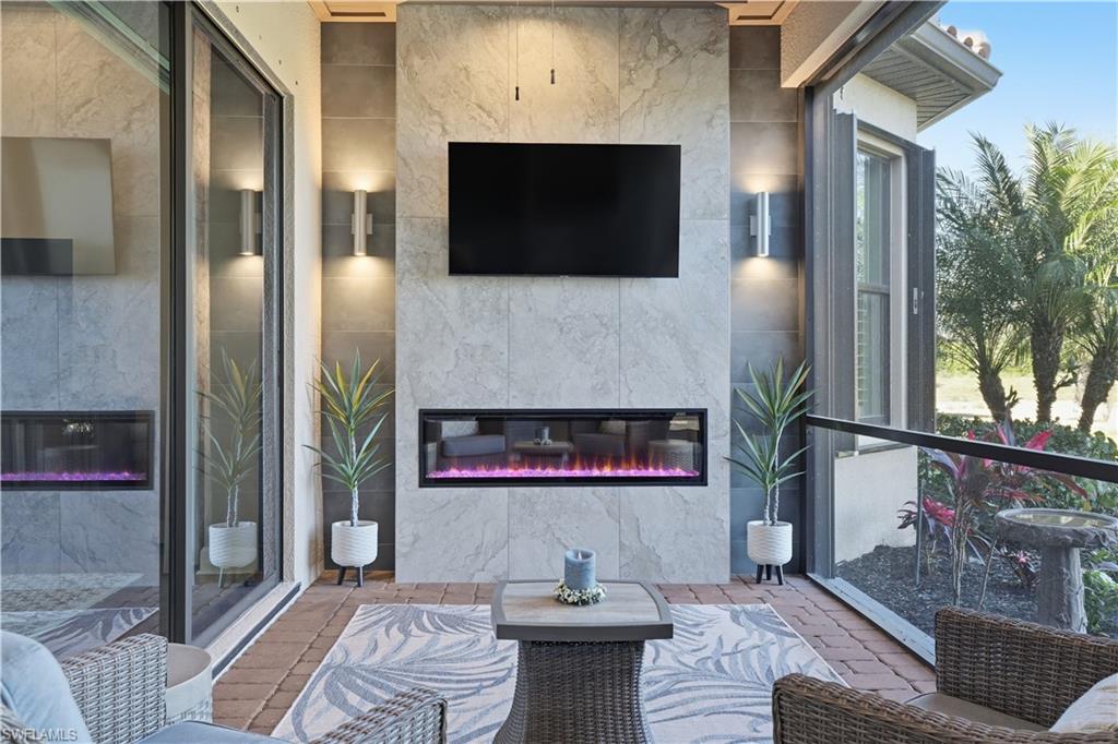 8665 Dilillo Court Naples, FL 34119 - Photo 23 of 42 a living room with furniture and a flat screen tv