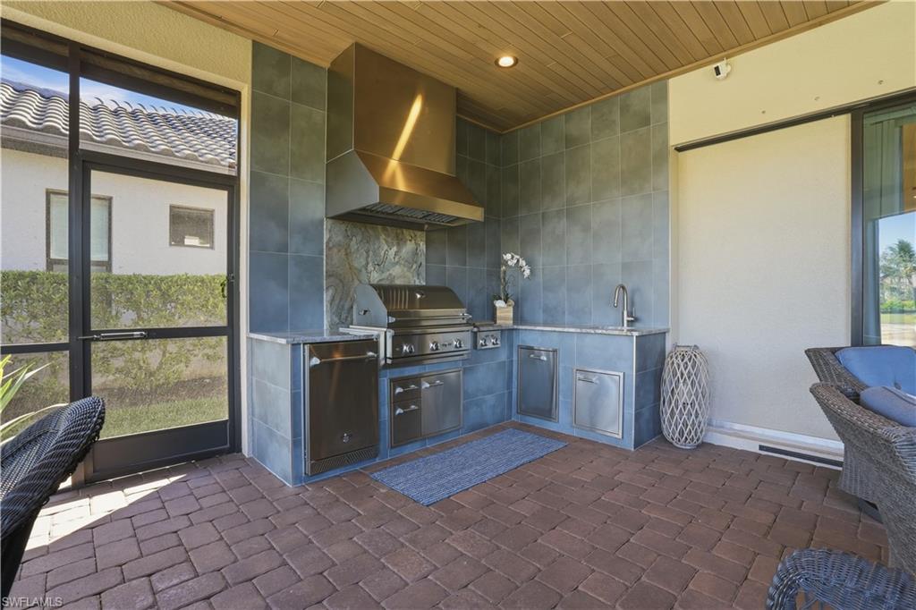 8665 Dilillo Court Naples, FL 34119 - Photo 24 of 42 a kitchen with a stove top oven cabinets and a refrigerator