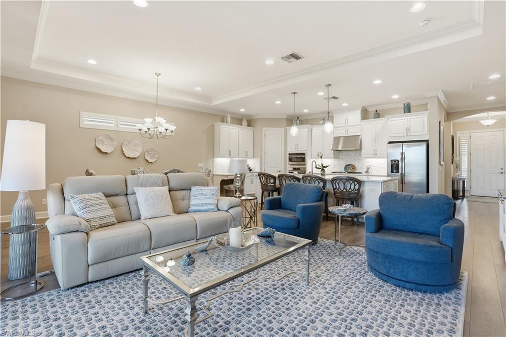 8665 Dilillo Court Naples, FL 34119 - Photo 4 of 42 a living room with furniture kitchen view and a chandelier