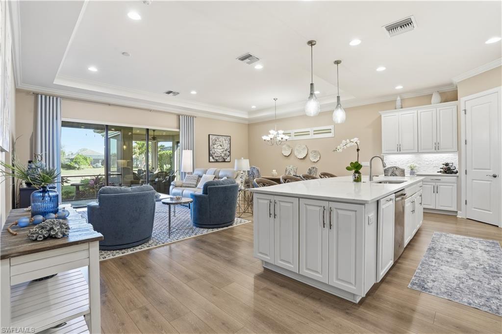 8665 Dilillo Court Naples, FL 34119 - Photo 8 of 42 a kitchen with counter top space and living room