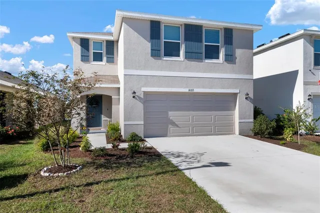 a front view of a house with a yard and garage