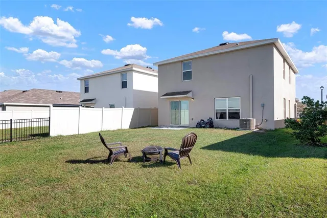 a view of a house with backyard and sitting area