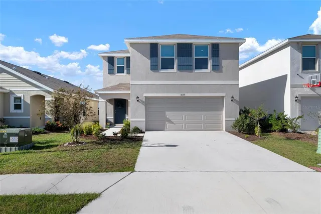 a front view of a house with a yard and garage