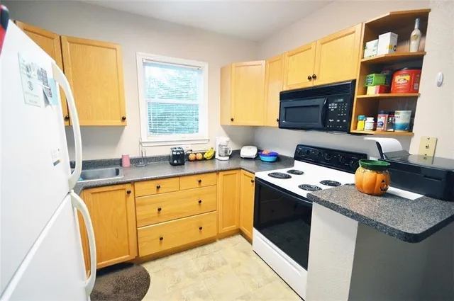 a kitchen with stainless steel appliances granite countertop a stove a sink and a microwave