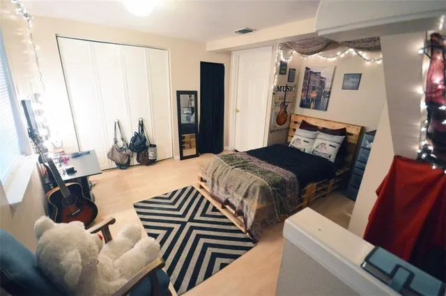 a bedroom with a bed and wooden floor