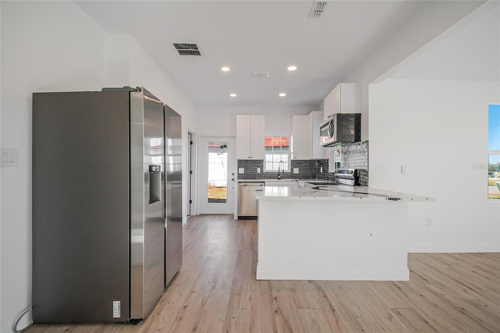 38835 Pine Street Umatilla, FL 32784 - Photo 23 of 36 a kitchen with a refrigerator a sink and cabinets