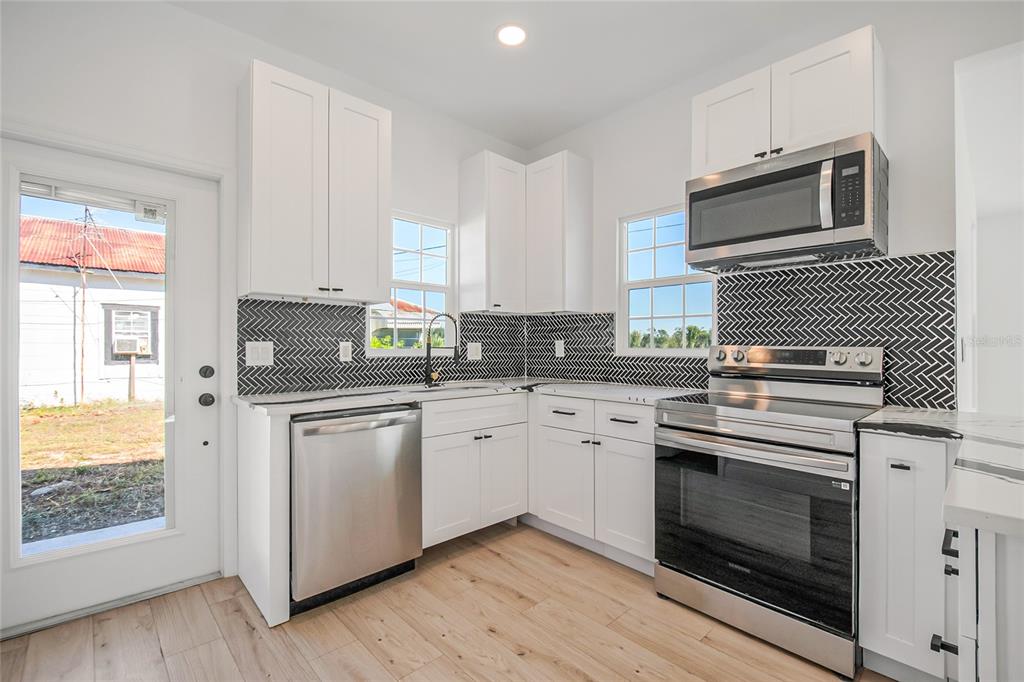 38835 Pine Street Umatilla, FL 32784 - Photo 24 of 36 a kitchen with granite countertop white cabinets stainless steel appliances and a sink