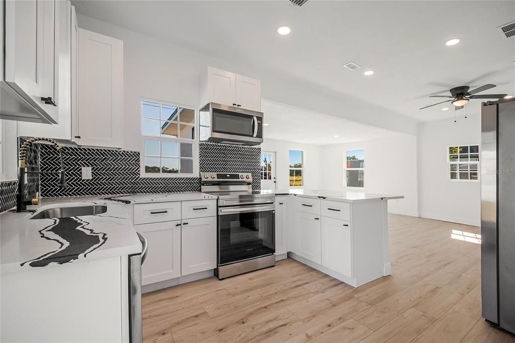 38835 Pine Street Umatilla, FL 32784 - Photo 25 of 36 a kitchen with stainless steel appliances granite countertop a stove and a sink