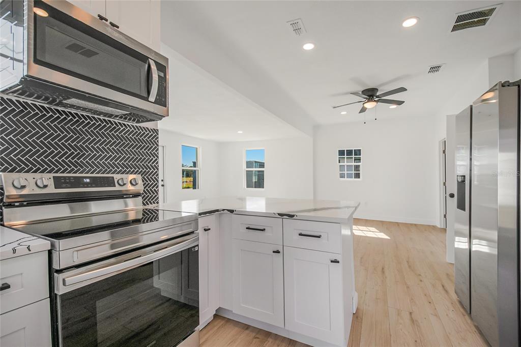 38835 Pine Street Umatilla, FL 32784 - Photo 26 of 36 a kitchen with granite countertop a stove cabinets and stainless steel appliances