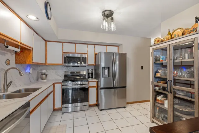 a kitchen with stainless steel appliances a refrigerator sink and cabinets