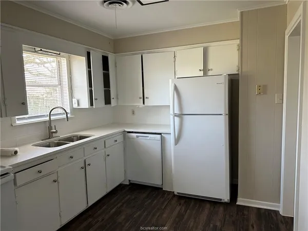 a kitchen with appliances a sink and a window