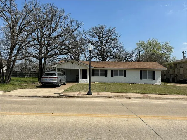 a view of a house with a yard and tree s