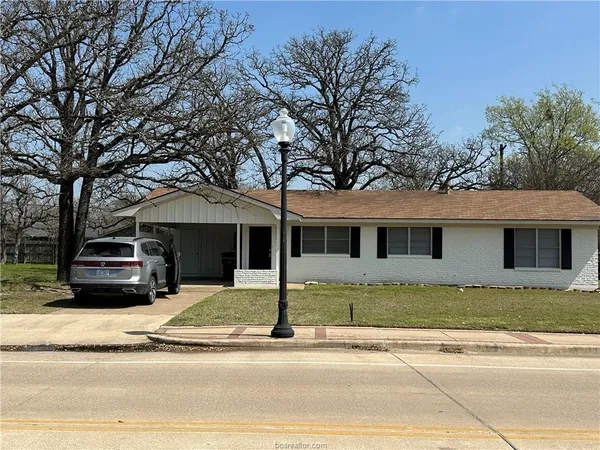 a house that has a tree in front of it
