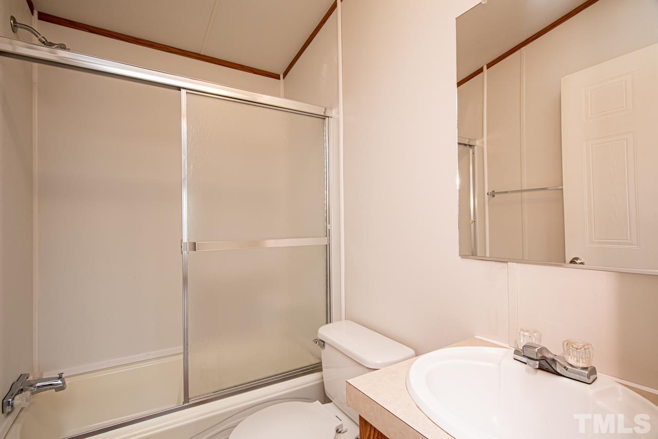 1545 Cheves Road Zebulon, NC 27597 - Photo 12 of 28 a bathroom with a sink mirror vanity and toilet