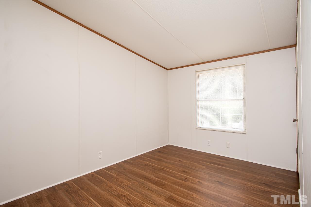 1545 Cheves Road Zebulon, NC 27597 - Photo 14 of 28 an empty room with wooden floor and windows
