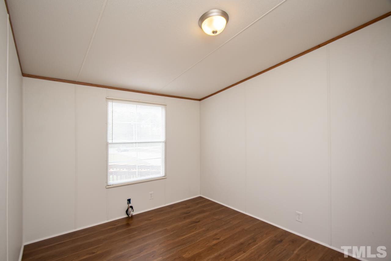1545 Cheves Road Zebulon, NC 27597 - Photo 16 of 28 an empty room with wooden floor and windows