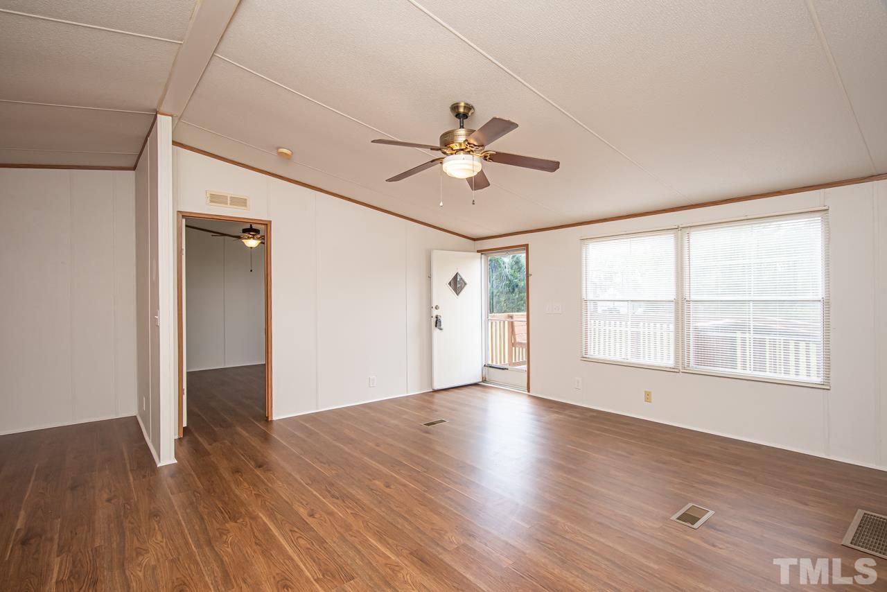 1545 Cheves Road Zebulon, NC 27597 - Photo 17 of 28 a view of an empty room with wooden floor and a window