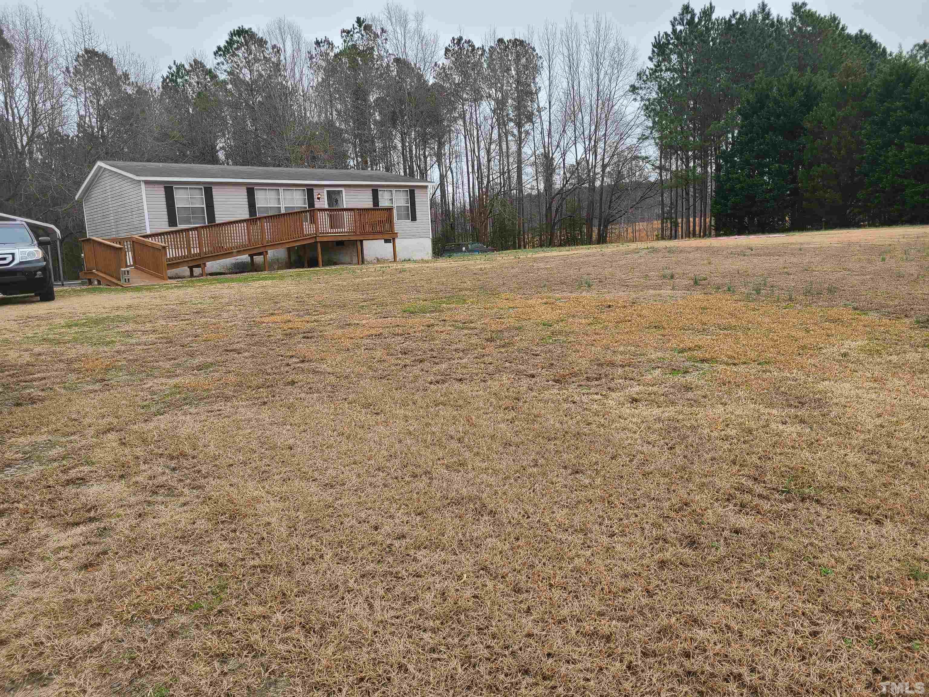 1545 Cheves Road Zebulon, NC 27597 - Photo 4 of 28 a view of house with yard and trees in the background