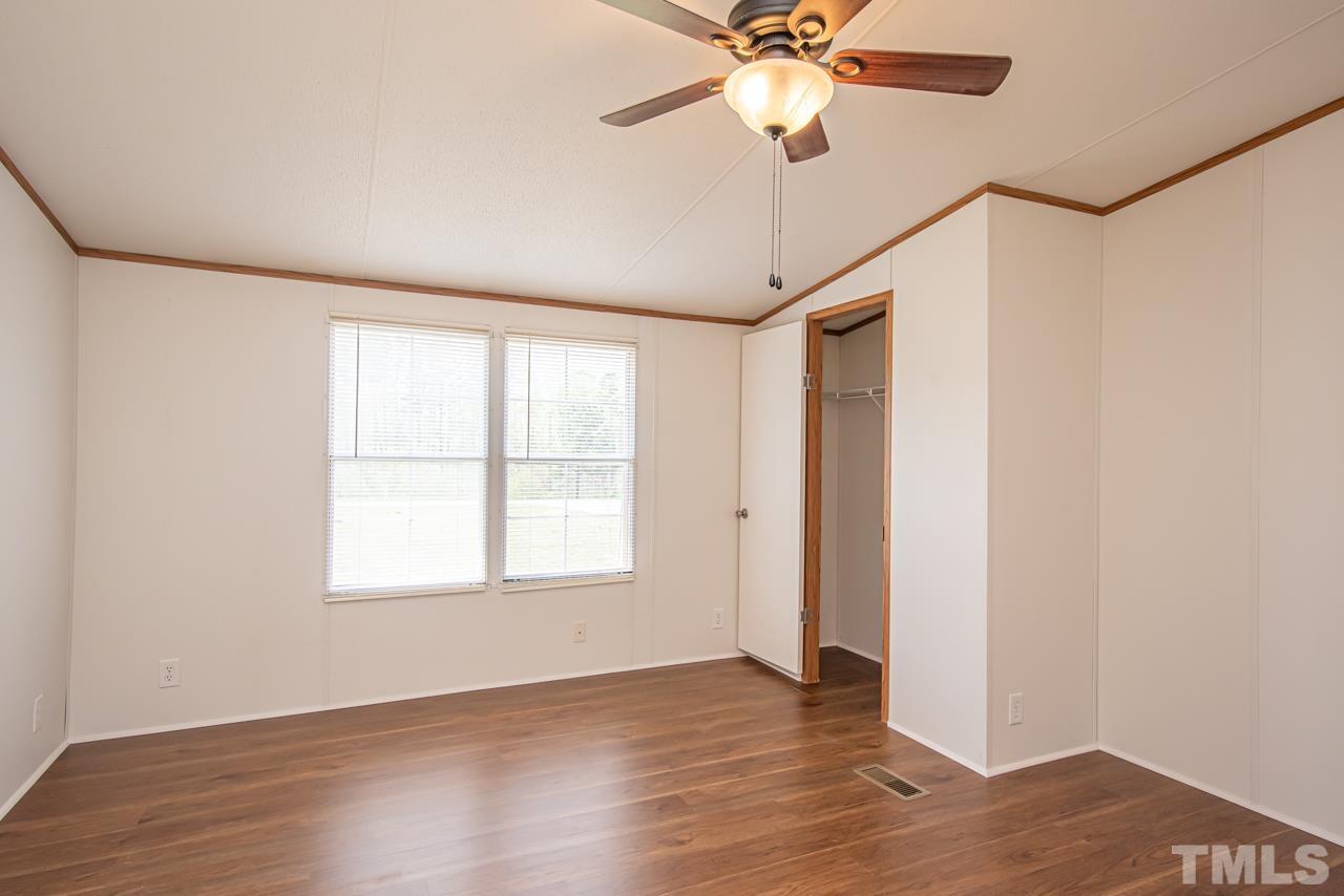1545 Cheves Road Zebulon, NC 27597 - Photo 5 of 28 a view of an empty room with wooden floor and a window