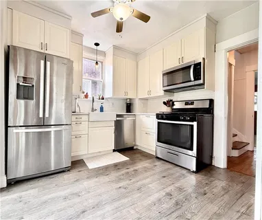 a kitchen with white cabinets and stainless steel appliances