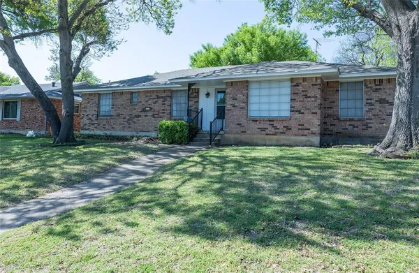 a view of a brick house with a yard